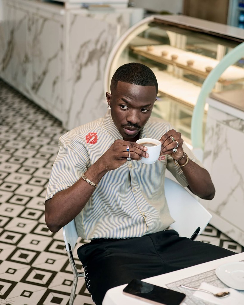 Model wearing DARKOS Hickey Strip Shirt in a cafe